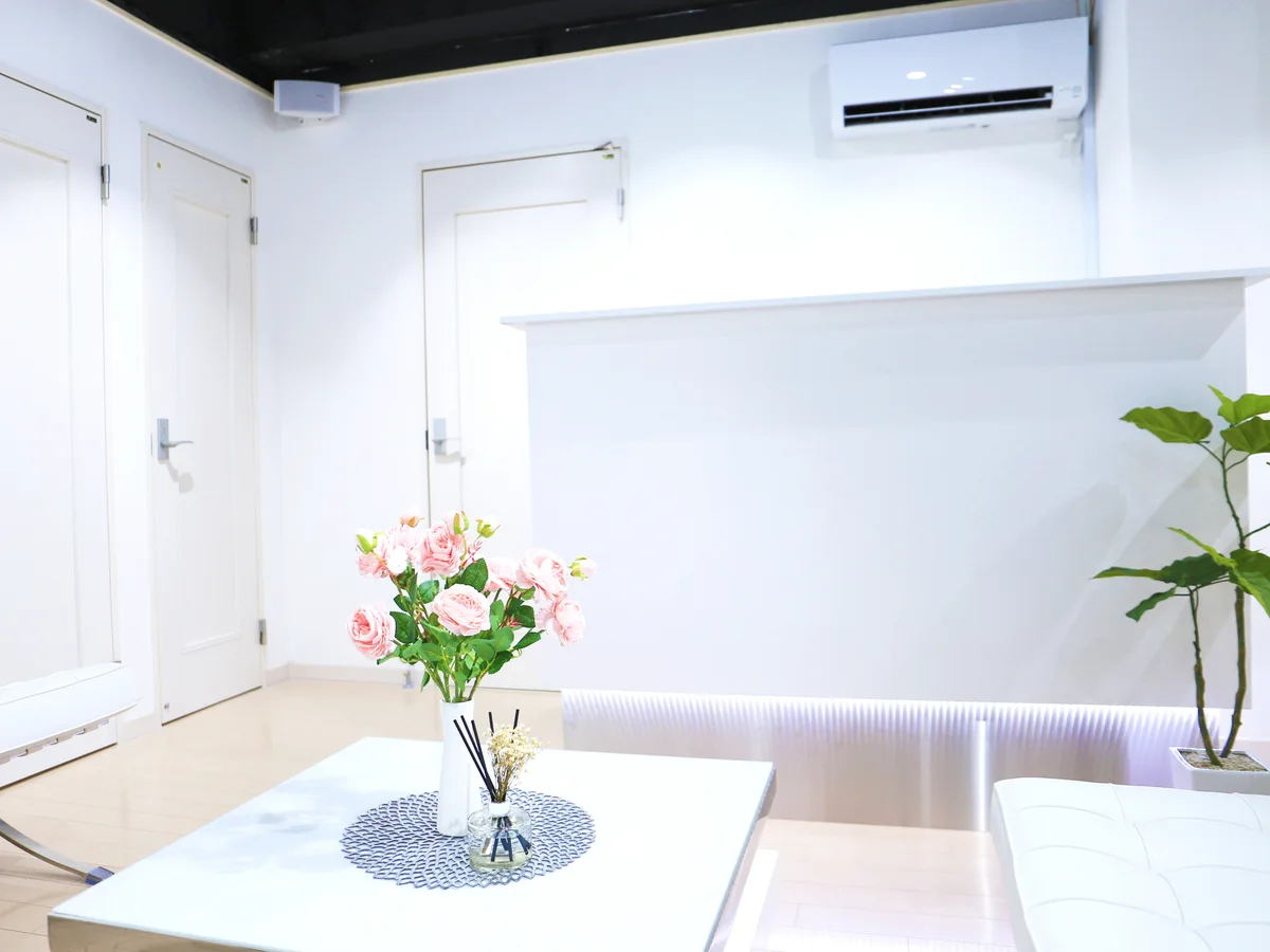 花を飾ったテーブルと観葉植物がある池袋店の休憩スペース